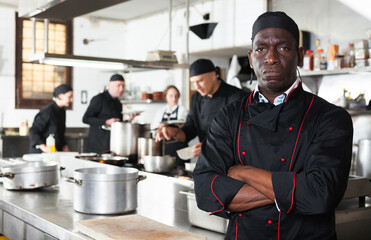Dissatisfied african american male chef in kitchen of restaurant. High quality photo