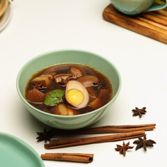 Sweet brown stewed eggs soup(Kai Palo) with pork on dinning table