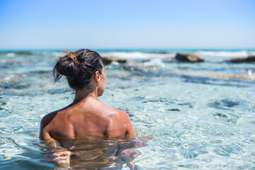 Woman bathing in a heavenly sea of turquoise water.