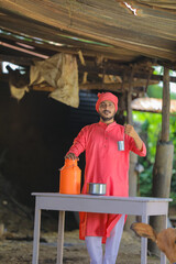 Indian farmer or milkman collecting milk at dairy farm