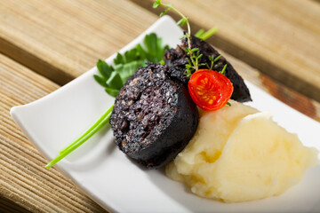 Delicious Catalan blood sausage with rice with garnish of mashed potatoes, fresh tomatoes and greens