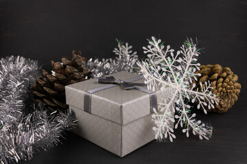 Fototapeta na wymiar Gift box Christmas tinsel and pine cones