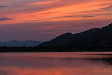 マジックアワーの綺麗な夕焼けと池に反射した夕焼け空