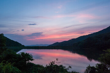 Fototapeta na wymiar マジックアワーの綺麗な夕焼けと池に反射した夕焼け空