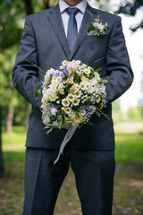 wedding bouquet in the hands of the groom