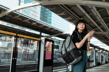 Thai backpacker waiting for a train.