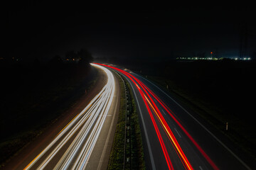 Vehicle car light trails on highway in red and white color. Trafic at night, long exposure