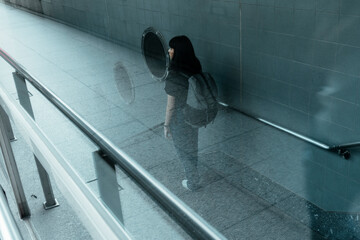 Asian woman walking into metro station.