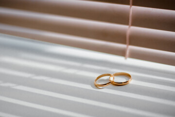 two traditional wedding gold engagement rings lie