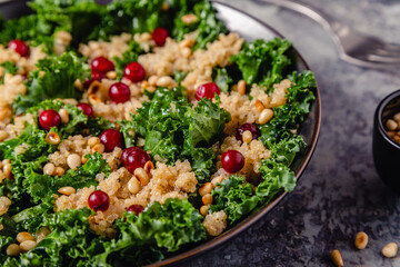Healthy raw kale and quinoa salad with cranberry and pine nut.