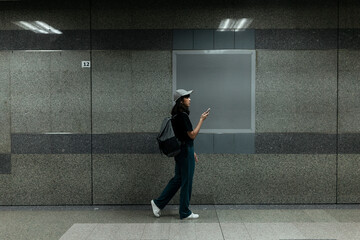 Copy space - traveler woman using smartphone at metro station.