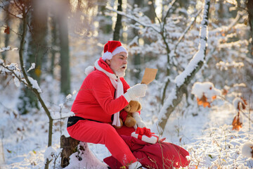 Santa Claus with Gift and teddy bear read Christmas wish list.