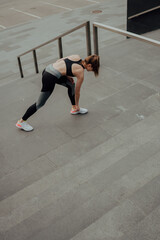 Obraz premium A young Caucasian girl, trains on the street, in sportswear, in the city.