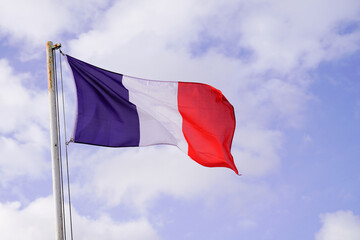 Naklejka na ściany i meble French flag of France wave over a blue cloud sky