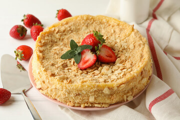 Plate with Napoleon cake with strawberry on white wooden background
