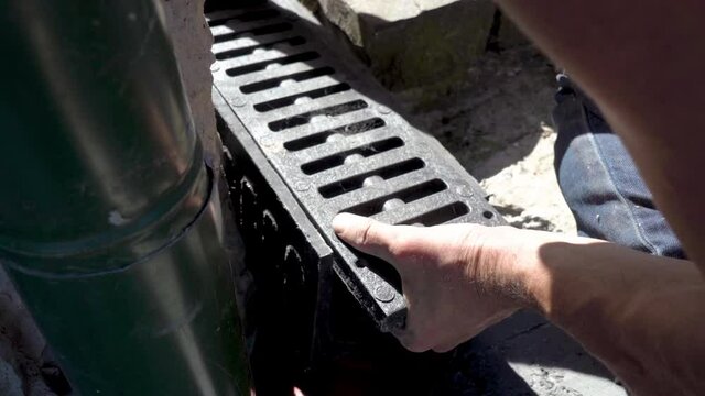 install Drainage tray,a man installs a plastic drainage gutter for rainwater drainage