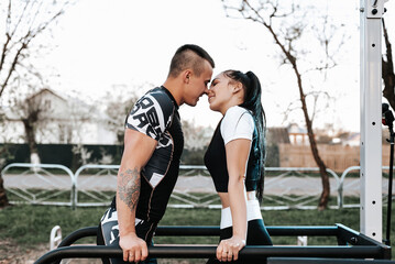 couple in love train together on the horizontal bars and play sports