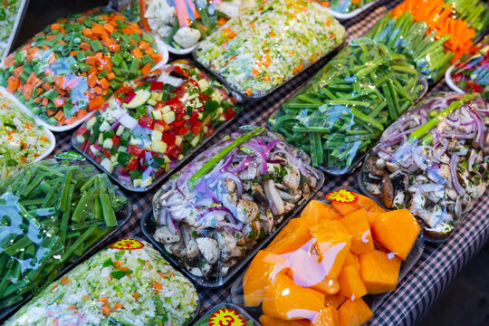 Mixed cut vegetables packed in plastic containers for sale in grocery shop..