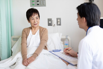 Obraz na płótnie Canvas 回診に来た医師と会話をする高齢者の女性