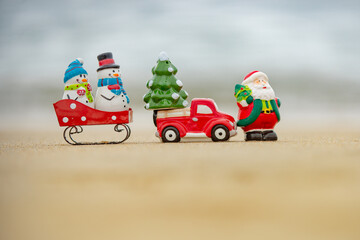 Toy Santa Claus snowman on sea, concept for travel destinations in hot tourist countries.