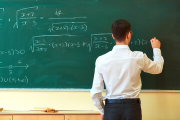 A student used white chalk to write mathematical formulas on the blackboard