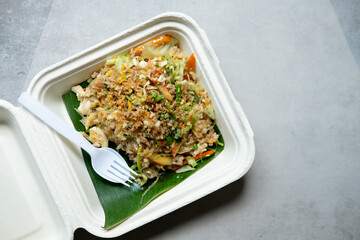 Stir fry glass noodle with minced pork and egg in Unbleached plant fiber food box.