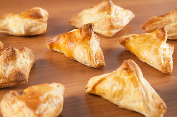 Freshly baked khachapuris with cheese on a wooden table.