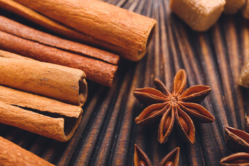 Cinnamon sticks and anise on wooden background, closeup