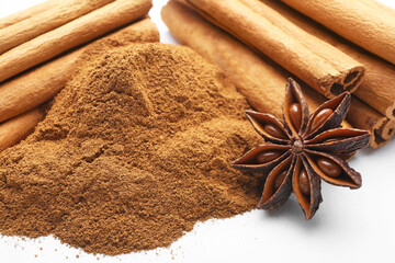 Cinnamon sticks, powder and anise on white background, closeup