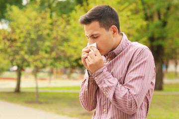 Fototapeta premium Young man suffering from allergy outdoors