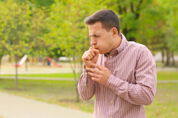 Fototapeta premium Young man suffering from allergy outdoors