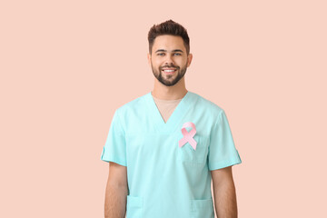 Doctor with pink ribbon on color background. Breast cancer awareness concept