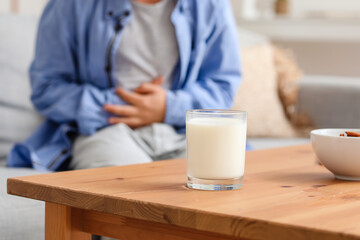 Fototapeta na wymiar Glass of milk and little boy with dairy allergy at home