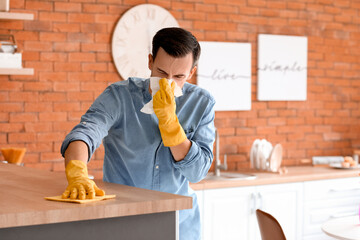 Allergic man cleaning his flat