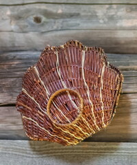The basket shell, woven from the vine closeup on the background of the old log walls