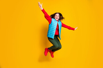 Full size photo of excited girl jump imagine fly plane feel carefree careless wear red sweater boots isolated over bright shine color background