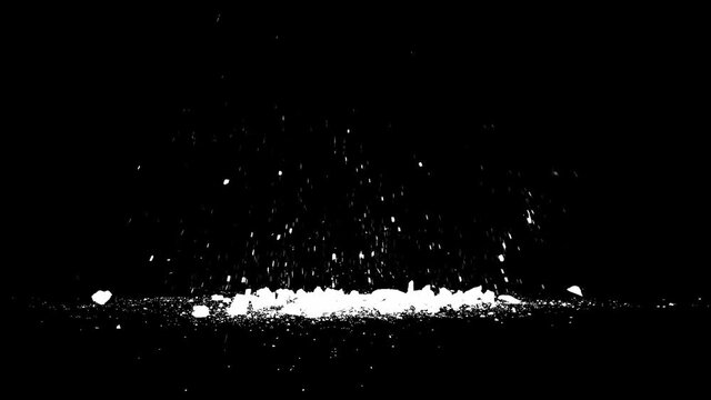 Blasted stone fragments and smoke, black background