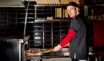 Chef putting pizza in oven for cooking