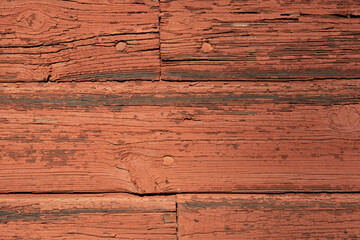 material texture of weathered wood boards with peeling red paint