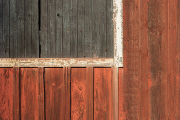 material texture of weathered wood boards with peeling red, gray and white paint