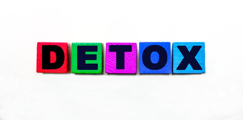 The word DETOX is written on colorful cubes on a light background