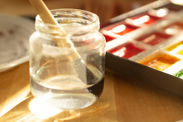 Pinceau dans un pot et boîte d'aquarelle