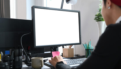 Cropped shot of a young designer sitting at graphic studio in front of computer while working online.