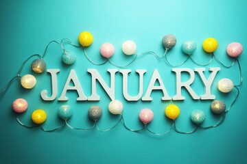 January alphabet letter with cotton ball LED decoration on blue background