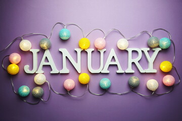 January alphabet letter with cotton ball LED decoration on purple background