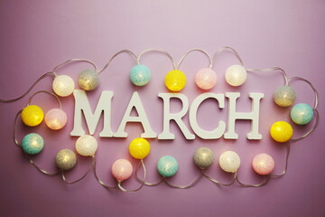 March alphabet letter with cotton ball LED decoration on purple background