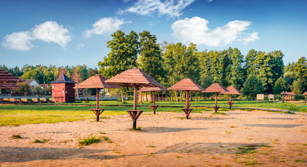 Wooden sun umbrellas on the empty beach. Calm morning scene on Shatsky National Park, Svityaz village location, Volyn region, Ukraine, Europe. Beauty of nature concept background..