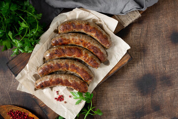 Fried sausages. Grilled sausages with spices on a wooden serving Board. Delicious meat sausages	