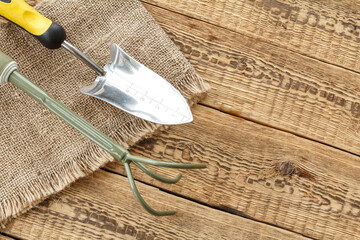Garden tools on sackcloth and wooden boards.