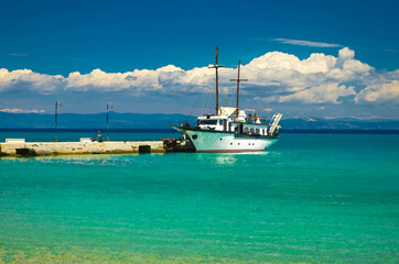 Naklejka premium Watercolor drawing of View of ship boat on blue paradise water of Toroneos kolpos gulf, blue sky white clouds over Sithonia peninsula near pier jetty in Pefkohori, Halkidiki, Macedonia, Greece